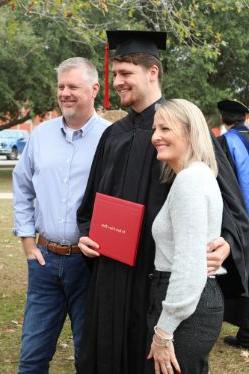 Student holds his deploma on graduation day at BUF